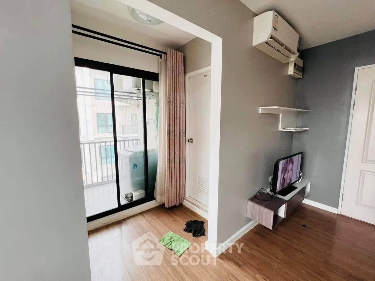 Modern living room with balcony access and sleek wooden flooring