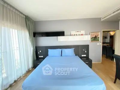 Spacious bedroom with modern decor and large window for natural light