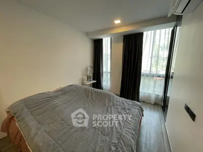 Cozy bedroom with large window and modern decor in urban apartment