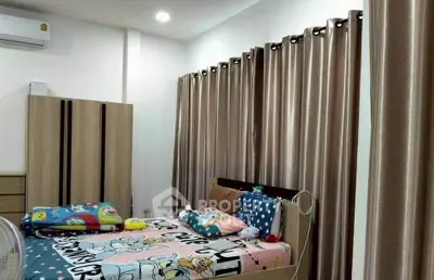 Cozy bedroom with modern decor and ample natural light, featuring stylish curtains and comfortable bedding.