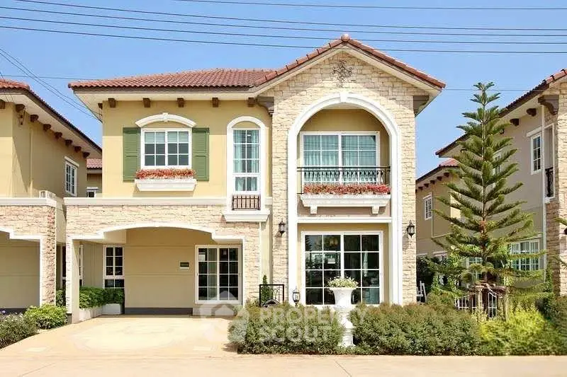 Elegant two-story house with classic architecture and lush landscaping in a serene neighborhood.