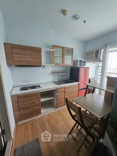 Cozy kitchen with wooden cabinets, dining table, and modern appliances in a bright apartment.