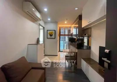 Modern apartment interior with sleek kitchen and cozy living area, featuring stylish decor and ample natural light.