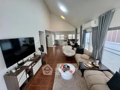 Spacious modern living room with open kitchen, stylish decor, and ample natural light.