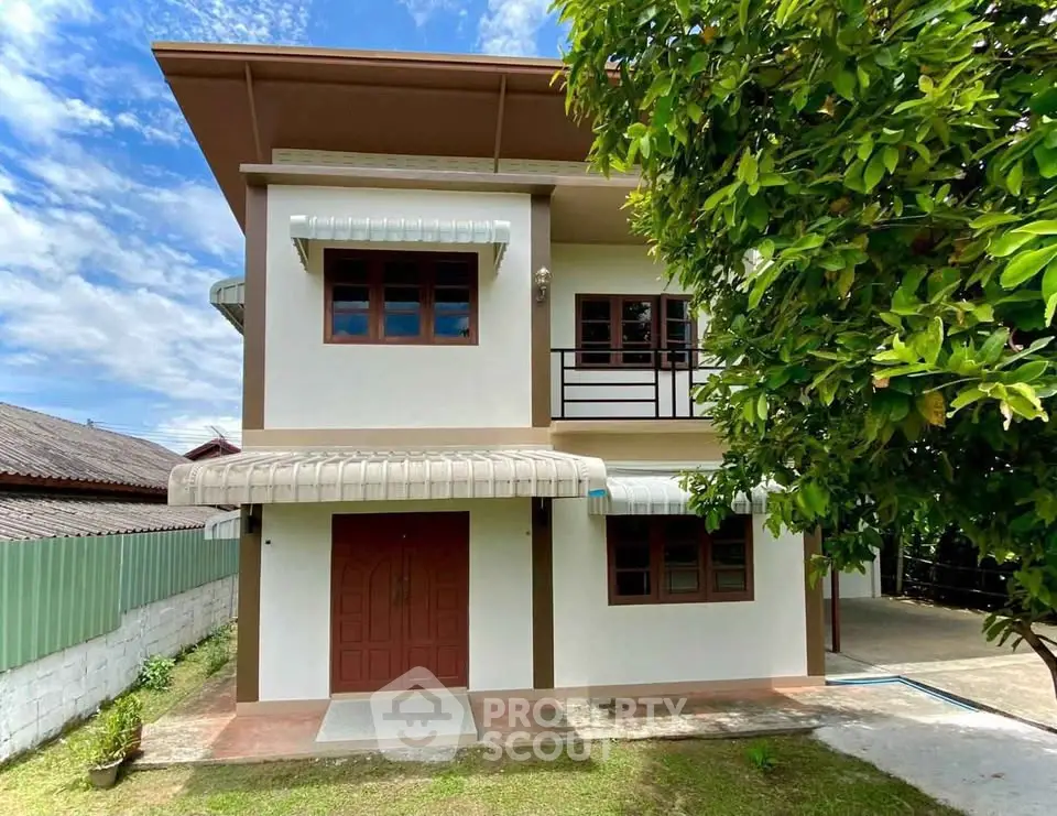 Charming two-story house with lush garden and modern exterior design.