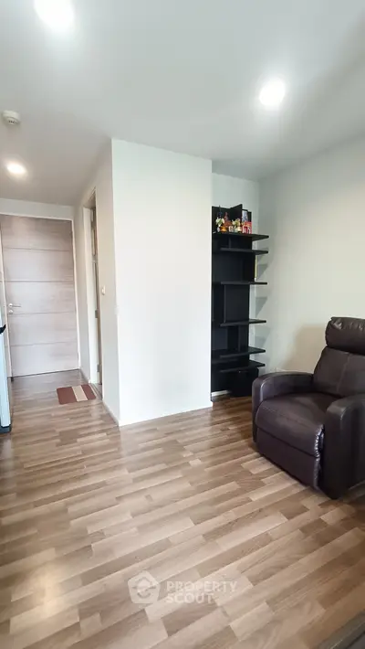 Modern living room with sleek wooden flooring and comfortable leather recliner.