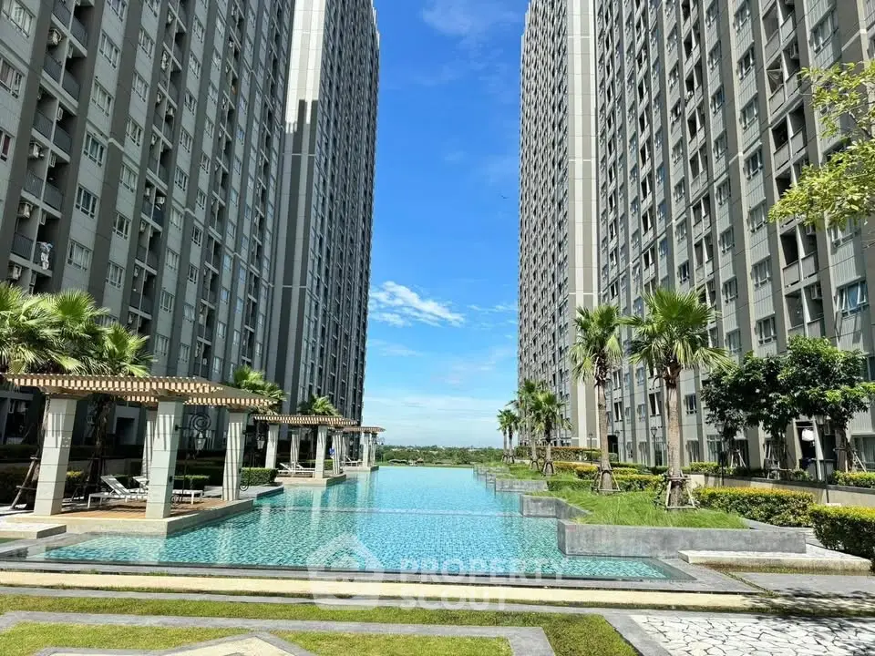 Luxurious high-rise apartment complex with stunning pool and lush landscaping.