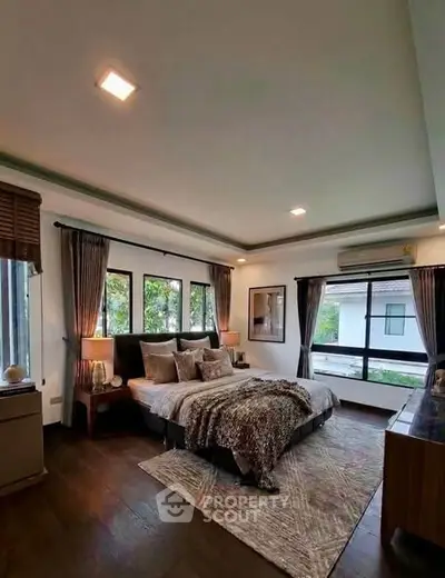 Luxurious bedroom with large windows and elegant decor, offering a serene and stylish retreat.