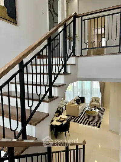 Elegant modern staircase with view of stylish living room and dining area