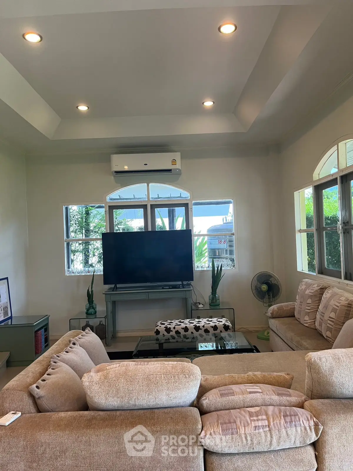 Spacious living room with cozy seating and large TV, perfect for relaxation.