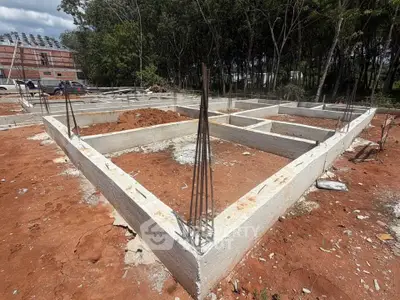Foundation of a new construction project on a spacious plot surrounded by greenery.