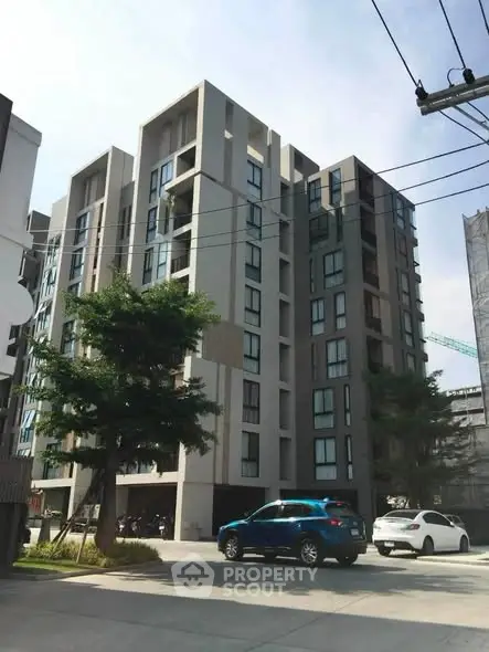Modern multi-story apartment building with contemporary design and large windows.