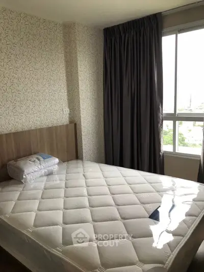 Cozy bedroom with large window and modern decor, perfect for relaxation.