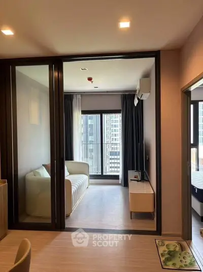 Modern living room with sliding glass doors and city view balcony in luxury apartment.