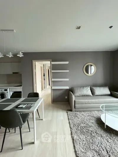 Modern living room with stylish furniture and open layout, featuring a cozy sofa and dining area.