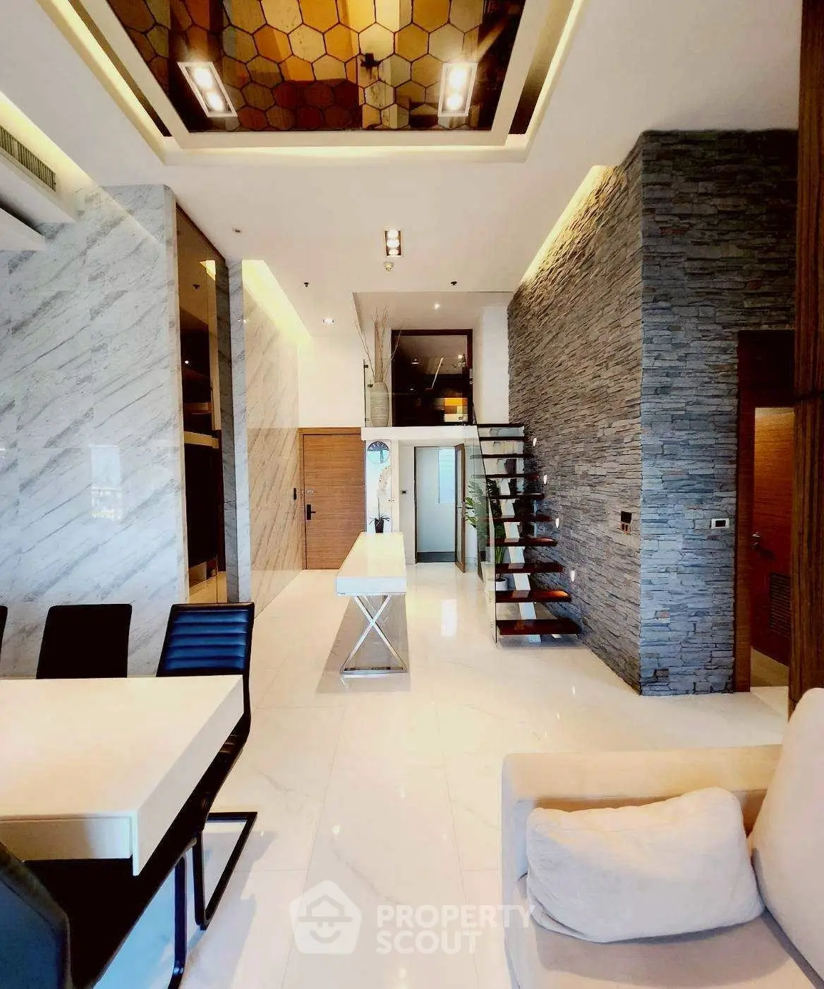 Luxurious modern living room with high ceilings and elegant stone wall accents.