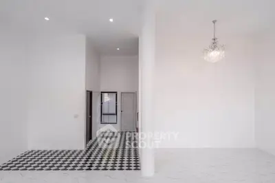 Spacious modern interior with high ceilings and elegant chandelier