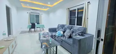 Spacious modern living room with stylish gray sofa and elegant dining area
