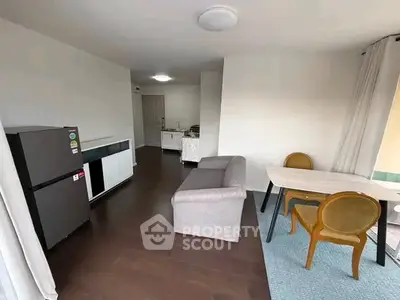 Modern living room with sleek furniture and open kitchen layout in a stylish apartment.