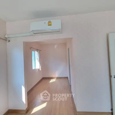 Bright and airy room with wooden flooring and air conditioning, perfect for a cozy living space.