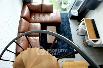 Stylish loft with spiral staircase and cozy leather sectional sofa