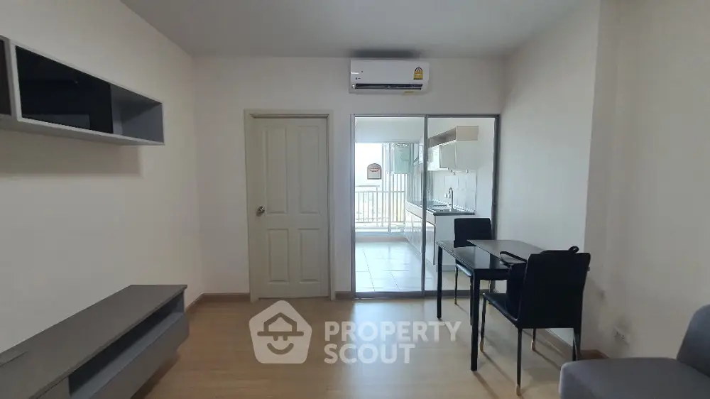 Spacious and well-lit living room with modern furnishings, leading to a cozy balcony, perfect for urban living.