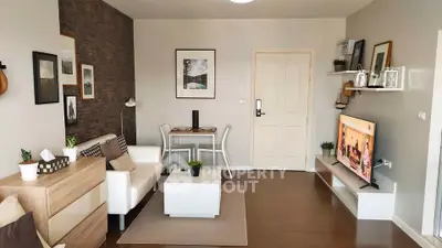 Modern living room with stylish decor, cozy seating, and wall-mounted TV, perfect for relaxation and entertainment.