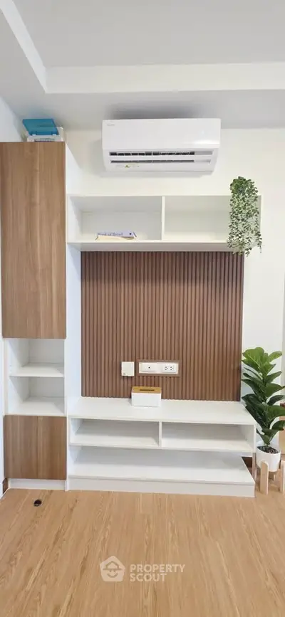 Modern living room with stylish wooden shelving and air conditioning unit, perfect for contemporary homes.