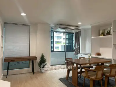 Modern dining area with wooden table and chairs, featuring large window and air conditioning unit.