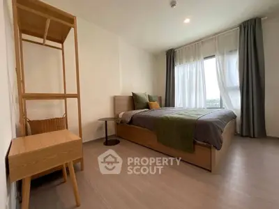 Modern bedroom with stylish wooden furniture and large window view.