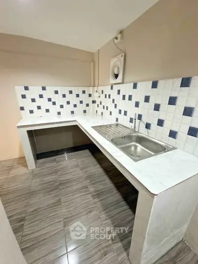 Modern kitchen with sleek tile backsplash and stainless steel sink