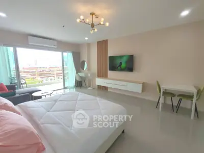 Spacious modern bedroom with balcony and city view, featuring stylish decor and ample natural light.
