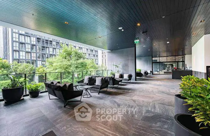 Modern outdoor terrace with stylish seating and lush greenery in a luxury apartment complex.