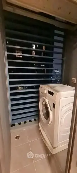 Compact laundry area with washing machine and modern design at night.
