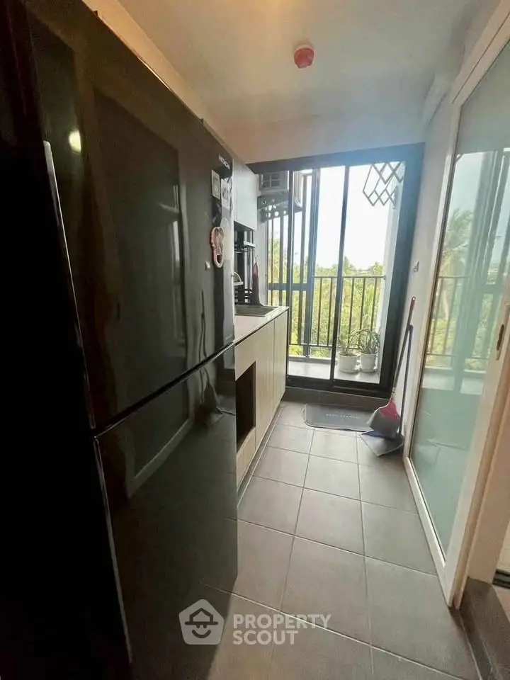 Modern kitchen with sleek black fridge and balcony view