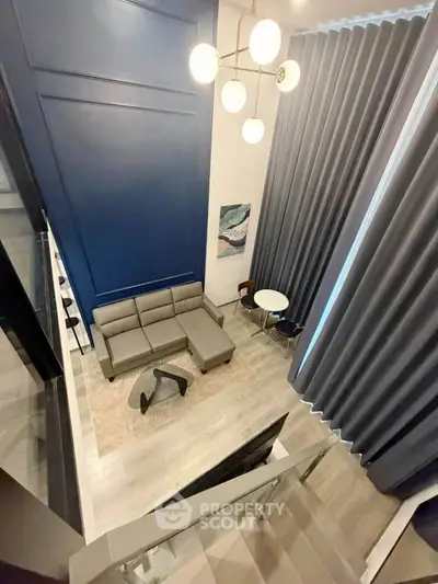 Modern loft-style living room with high ceilings and elegant decor.
