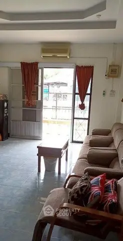 Spacious living room with cozy seating and natural light, perfect for relaxation.