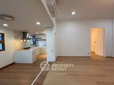 Spacious open-plan living room with modern kitchen and wooden flooring