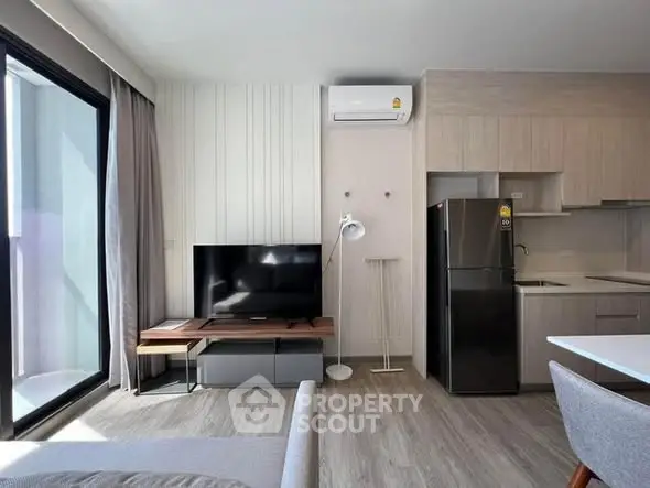 Modern living room with sleek kitchen and large window for natural light