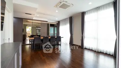 Spacious modern living room with elegant dining area and hardwood floors