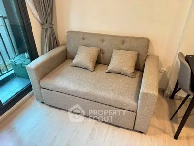 Cozy living room with modern sofa and balcony view, perfect for relaxation and comfort.
