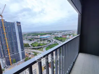 Stunning high-rise balcony view overlooking cityscape and highway, perfect for urban living.