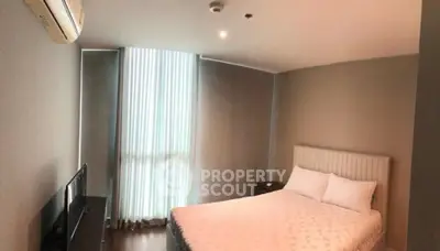 Cozy bedroom with modern decor and natural light in a stylish apartment.