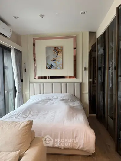 Luxurious bedroom with elegant decor and floor-to-ceiling windows in modern apartment.