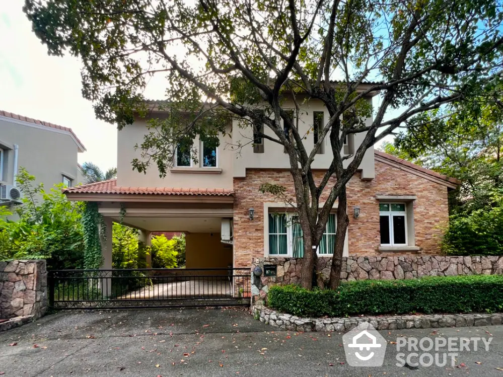 Charming two-story house with stone facade and lush greenery in a serene neighborhood.