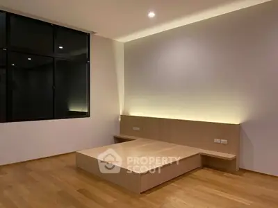 Modern minimalist bedroom with wooden flooring and built-in lighting