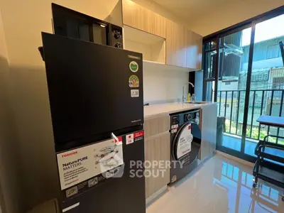 Modern kitchen with sleek appliances and balcony view in a stylish apartment.