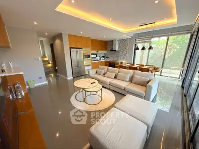 Luxurious open-plan living room with modern kitchen and large windows offering garden views.