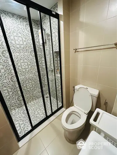 Modern bathroom with stylish patterned tiles and glass shower enclosure