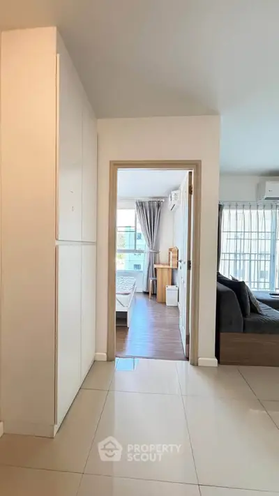 Modern apartment interior with open layout, featuring a cozy living room and a bright bedroom.